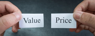 Two hands each holding a small paper—one labeled ‘Value’ and the other labeled ‘Price’—symbolizing the balance between value and pricing in business strategy