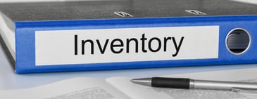 Blue office binder labeled inventory on a desk with documents and a pen, symbolizing Amazon inventory management and liquidation