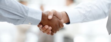 lose-up of two professionals shaking hands, symbolizing strong vendor relationships and successful collaboration with Amazon.